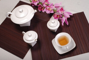 Beautiful bone-china tea set with tea pot and cups and saucers. Minimal and elegant design.