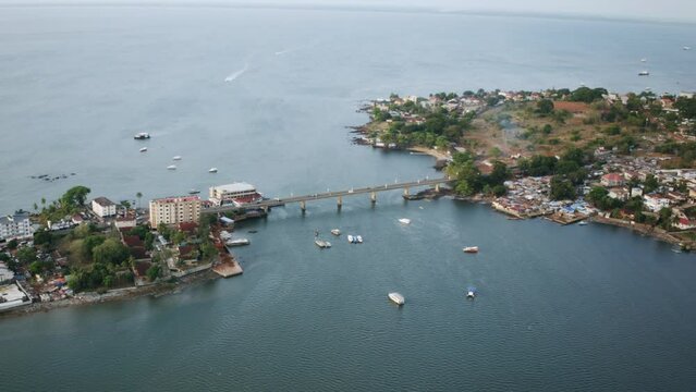 Aerial hyperlapse of the Aberdeen Bridge in Freetown, Sierra Leone with boats driving around.