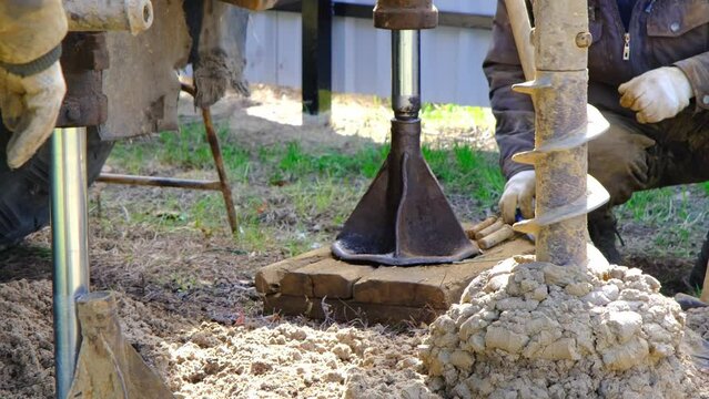 Team of workers with drilling rig on car are drilling artesian well for water in ground. Insertion of metal casing pipe into ground, installation of individual drinking supply, June 28, 2022, Russia, 