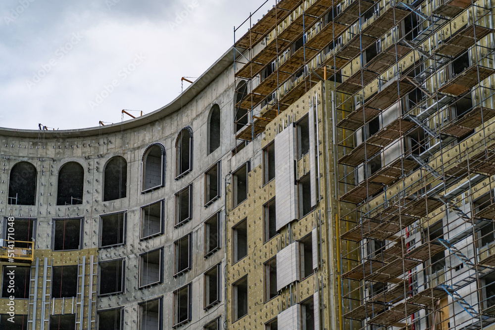 Poster housing construction, apartment frame with scaffolding. building under construction with partially a