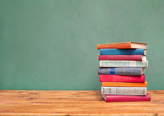 stack of books on the table against the background of the blackboard