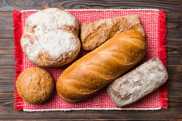 Assortment of freshly baked bread with napkin on rustic table top view. Healthy unleavened bread. French bread