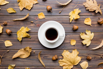 Flat lay composition with colorful Autumn cup of coffee and leaves on a color background. top view