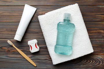 Obraz na płótnie Canvas Mouthwash and other oral hygiene products on colored table top view with copy space. Flat lay. Dental hygiene. Oral care products and space for text on light background. concept