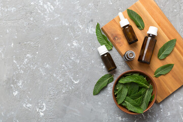 Natural Mint Essential Oil in a Glass Bottle. organic cosmetics with herbal extracts of mint on...