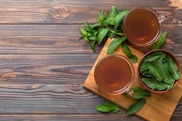 Cup of mint tea on table background. Green tea with fresh mint top view with copy space
