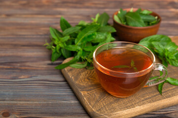 Cup of mint tea on table background. Green tea with fresh mint top view with copy space