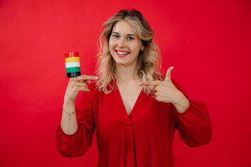 blonde beautiful woman holding in hand roll set of duct Insulation tape on red background