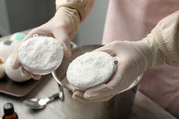 Woman in gloves making bath bomb at table, closeup