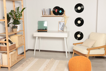 Room interior with stylish turntable on white table and vinyl records
