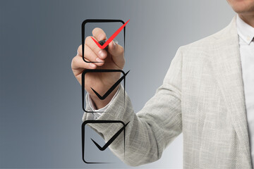 Man pointing at red check mark in box on virtual screen, closeup © New Africa
