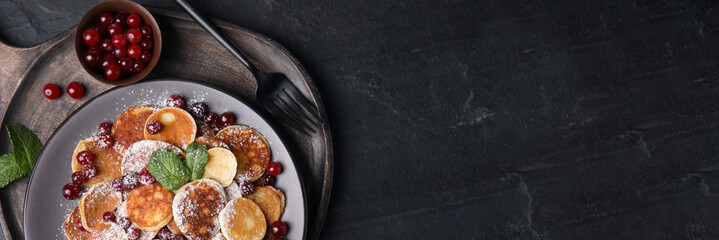 Cereal pancakes with cranberries served on black table, top view with space for text. Banner design