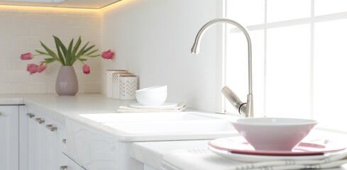 Obraz na płótnie Canvas Beautiful ceramic dishware and bouquet on countertop in kitchen. Banner design