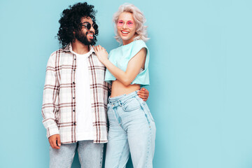 Smiling beautiful woman and her handsome boyfriend. Sexy cheerful multiracial family having tender moments on beige background in studio. Multiethnic models hugging. Embracing each other.Love concept