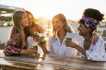 Happy girls having fun drinking cocktails at bar on the beach - Soft focus on center girl face