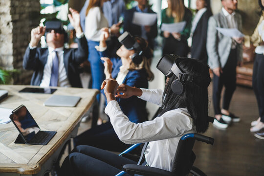 Diverse business people wearing virtual reality goggles inside office - Focus on african girl sitting on wheelchair