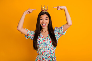 Photo of young cheerful egocentric female showing her luxurious royal crown diadem isolated on...