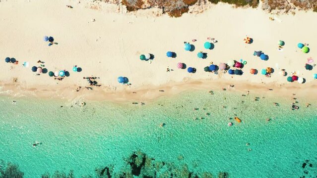 Estate in Salento - Marina di Lizzano - spiaggia con acqua turchese cristallina e gli ombrelloni colorati -  Puglia, Taranto, Italy - vista aerea, drone 4K 