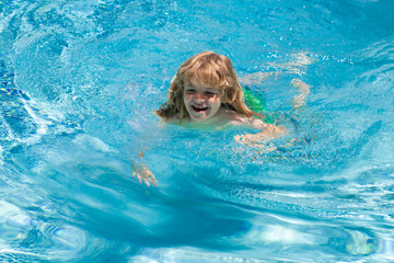 Happy child playing in swimming pool. Summer kids vacation. Little kid boy relaxing in a pool having fun during summer vacation.