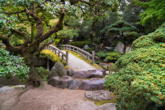 A path, a stone bridge and a pond in Gonaitei garden on a beautiful autumn day in Kyoto Imperial Palace in Kyoto, Japan.