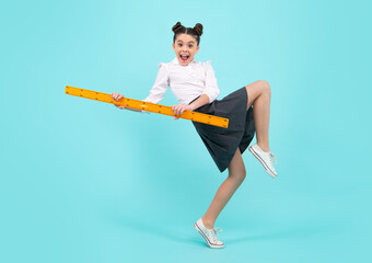 School girl holding measure for geometry lesson, isolated on blue background. Measuring equipment. Student study math. Crazy jump, jumping kids.