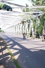 traffic in the city or iron bridge or jembatan konstruksi besi di kali Luk Ulo, Kebumen, Jawa...