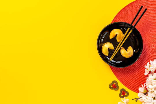 Chinese New Year tabble setting with fortune cookies and golden chopsticks