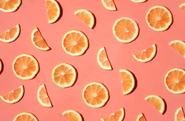 Pattern of many sliced lemons and oranges on a trendy bright pink background. Flat lay, top view. Summer freshness, detox, antioxidants, healthy lifestyle concept