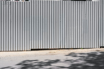 Big gray steel corrugated fence of construction site with copyspace for mockup at city street © Bonsales