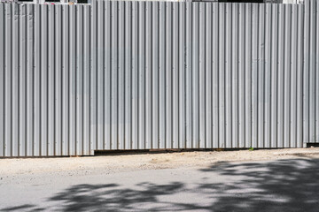 Big gray steel corrugated fence of construction site with copyspace for mockup at city street