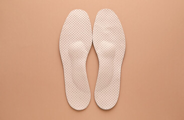 Orthopedic insoles on pale pink background, flat lay
