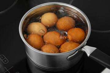 Boiling chicken eggs in saucepan on electric stove