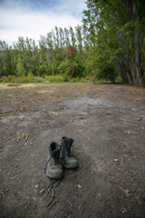 dirty and abandoned black trekking shoes in the field