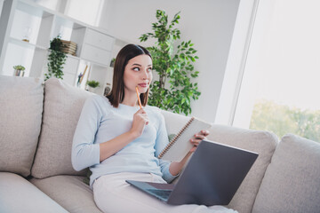 Portrait of creative minded girl sitting sofa pen touch chin brainstorming take notes free time...