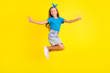 Fototapeta na wymiar Full body photo of small friendly person jumping arms fingers demonstrate v-sign isolated on yellow color background