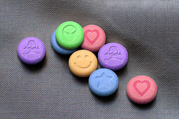 MDMA or Ecstasy pills on white fabric background