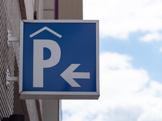 Blue parking sign in front of an underground parking garage  on a wall. Entry to the basement...