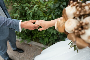 bride and groom holding hands with wedding rings