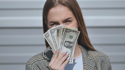 Young girl showing dollars in the street.