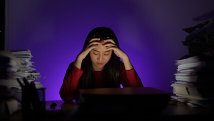 Stressed young asian woman sitting work overtime doing late time business at office in night on desk, Exhausted businesswoman concept.