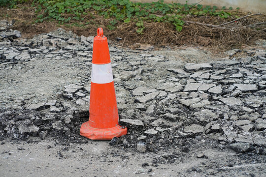 White orange traffic hazard cone on asphalt road repair,Thailand