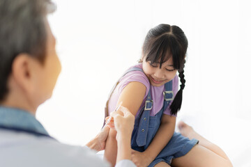 doctor inject vaccine to asian girl, Deltoid muscle injection technique, children immunization and health care promotion