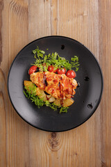 traditional dishes of European cuisine, delicacy, banquet snack. culinary dishes on a black plate on a wood background. restaurant service. top view