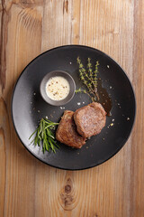 traditional dishes of European cuisine, delicacy, banquet snack. culinary dishes on a black plate on a wood background. restaurant service. top view