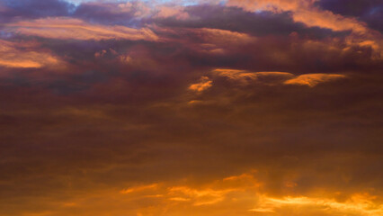 Naklejka na ściany i meble Ciel rougeoyant pendant un coucher de soleil, sous des nuages de haute altitude