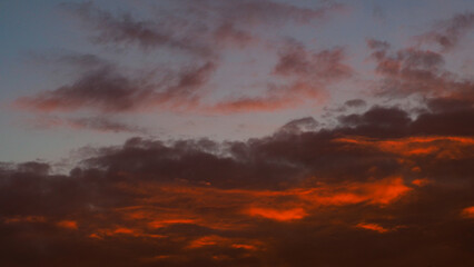 Ciel rougeoyant pendant un coucher de soleil, sous des nuages de haute altitude