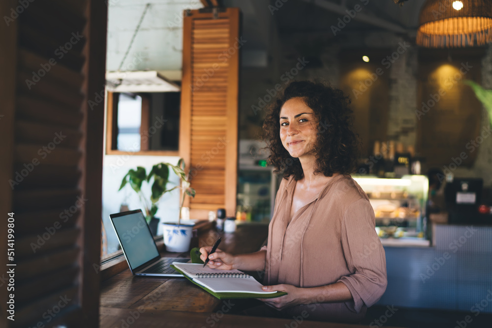 Aufkleber portrait of female student with education textbook and modern laptop device looking at camera during