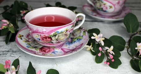 Two cups of tea with flowers on a wooden table