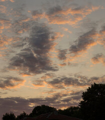 A landscape with an enchanting sunset. Panorama. Tragic gloomy sky. The last flashes of the sun on the storm clouds.