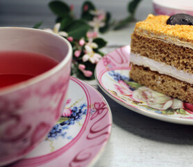 A cup of tea and a close-up cake on a wooden table.